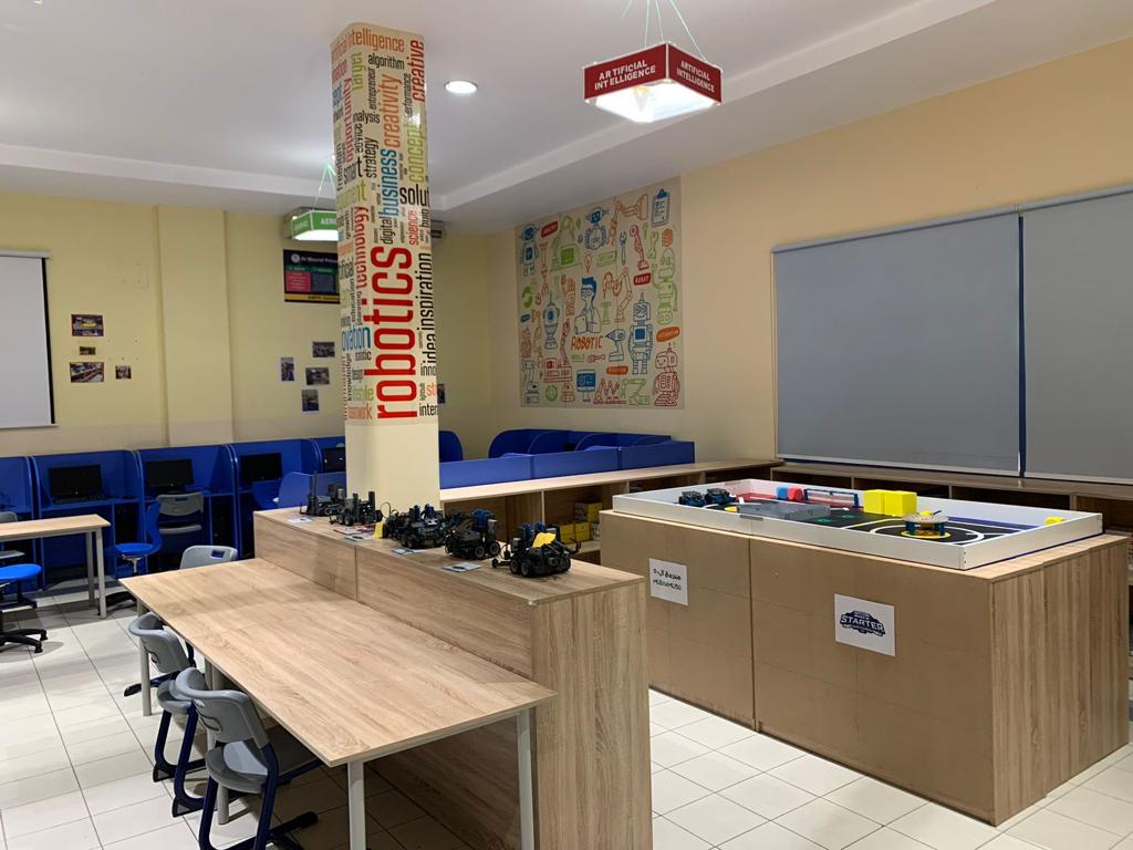 An AI and robotics lab implemented by EduStream in a UAE school, with robotics kits set out on the central workbench beside a competition mat