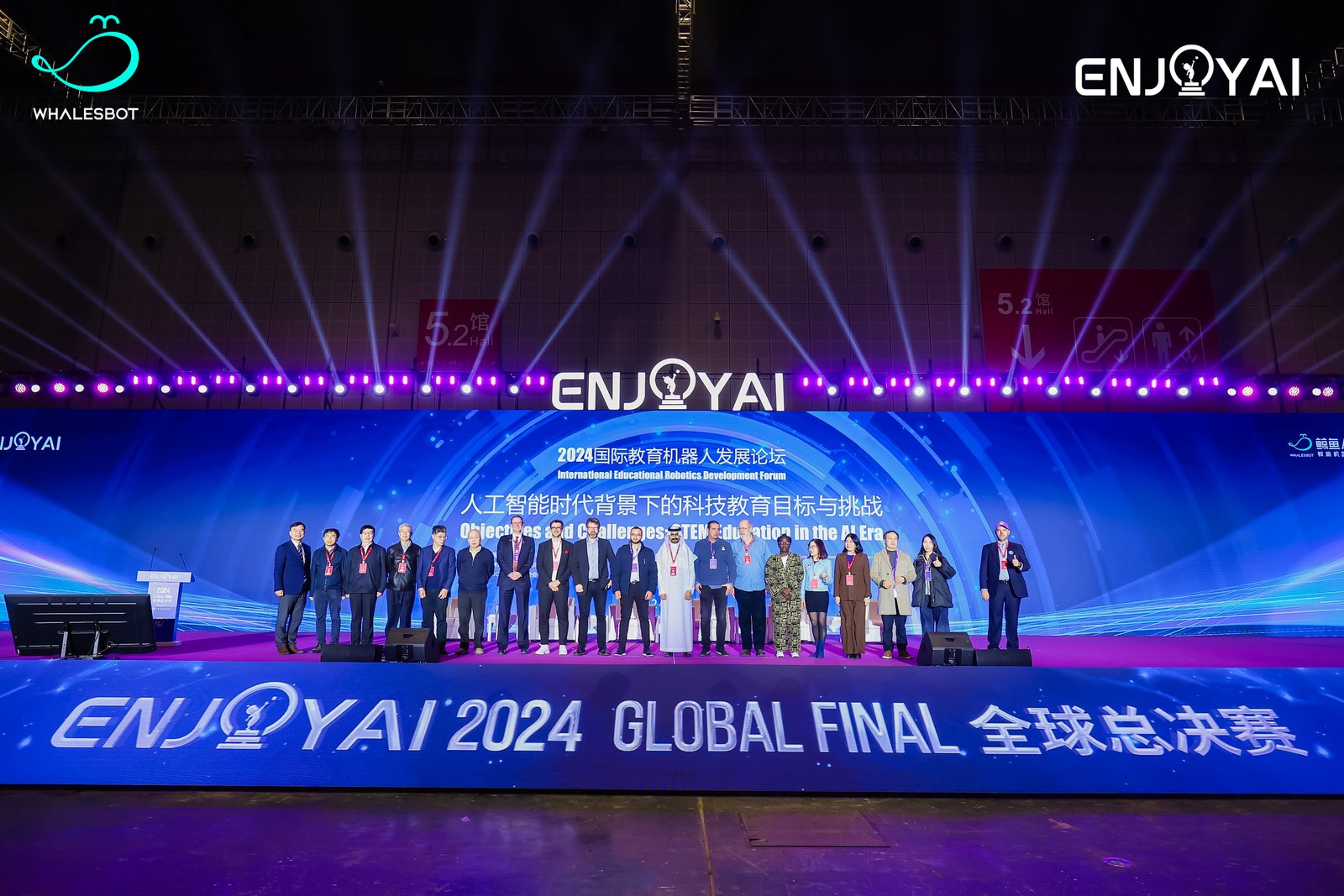 Team members standing on stage beneath the ENJOY AI 2024 Global Final screen