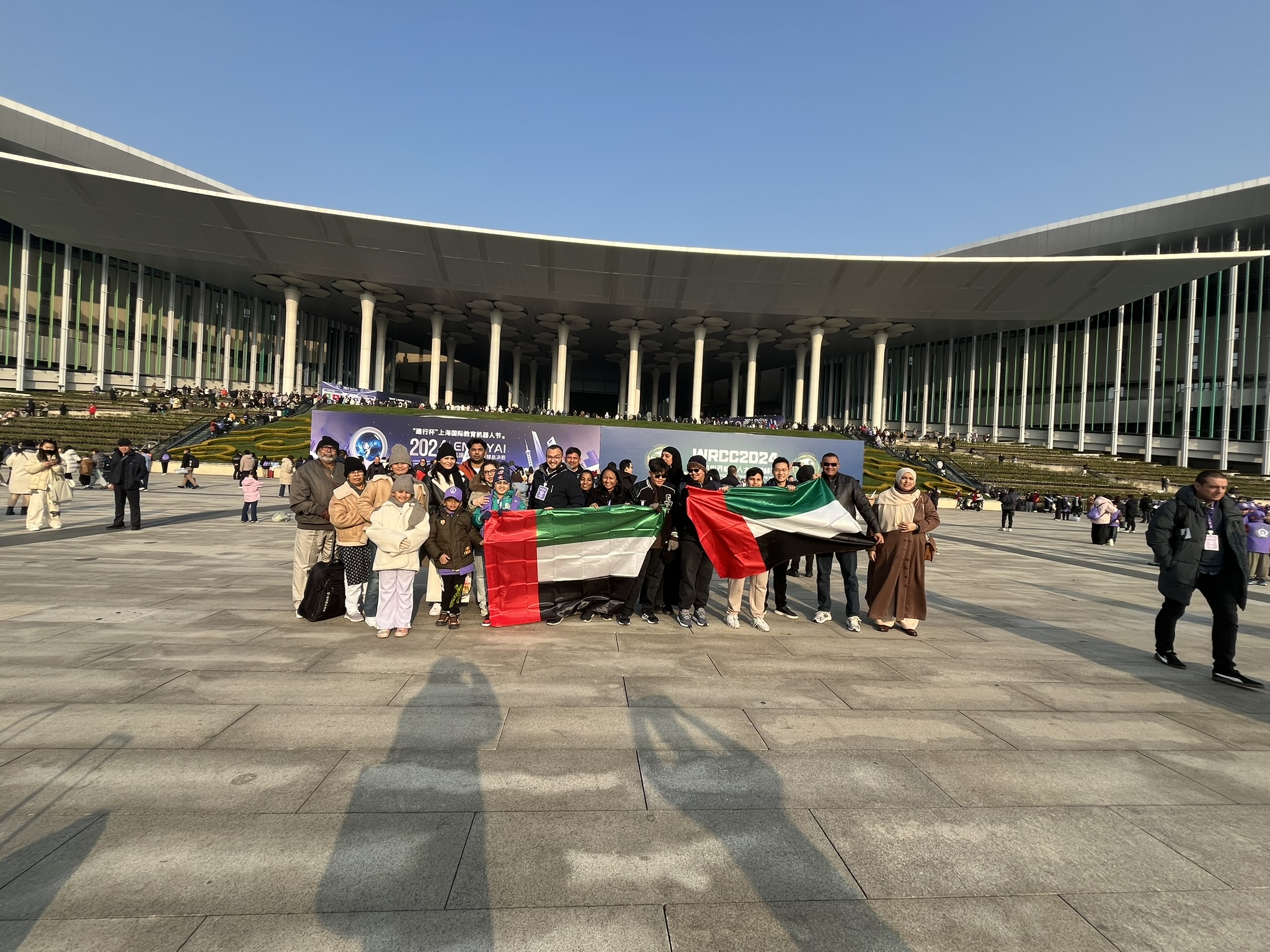 A UAE delegation group photo with the national flag at the competition venue