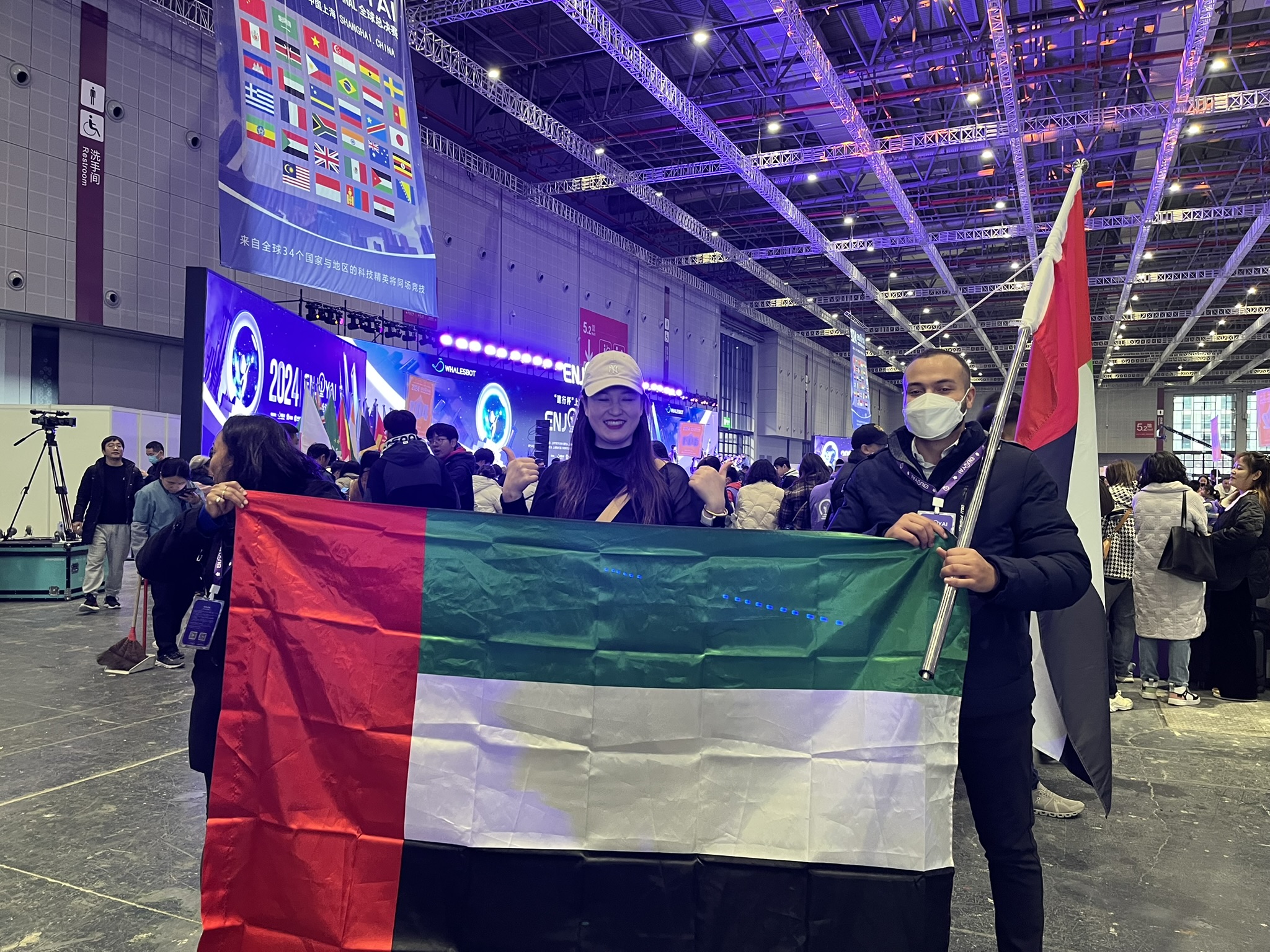 Participants holding the UAE flag inside the ENJOY AI competition arena