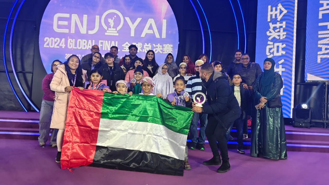 A team celebrating on stage with the UAE flag at the ENJOY AI global final