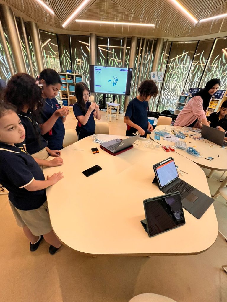 Students working on design and make tasks at shared tables in a school Design Technology space