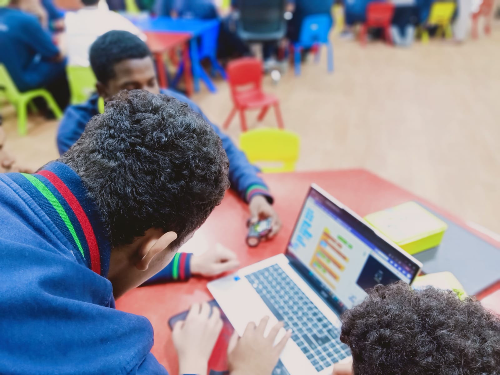 An EduStream facilitator supporting students coding a robot during a design and make session