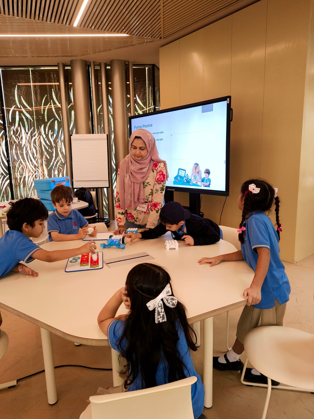 A teacher leading a hands-on session with young students in a transformed innovation lab