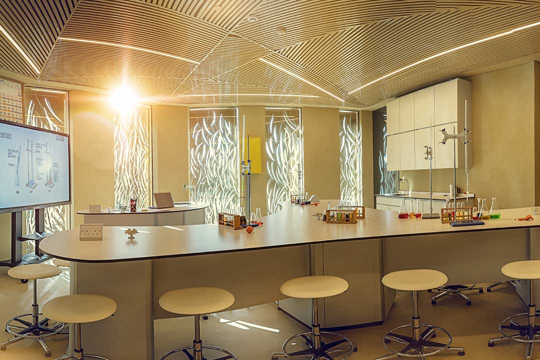 A transformed innovation lab in a UAE school with a curved collaborative worktop, feature lighting and a large display