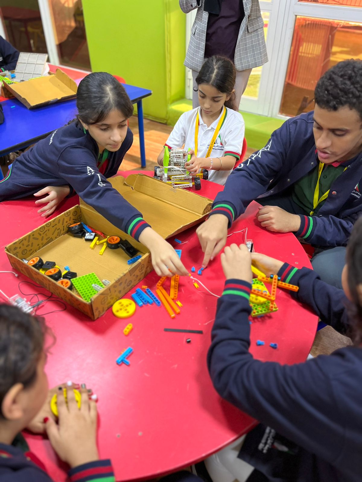 Students assembling parts from a components tray while prototyping in a school makerspace
