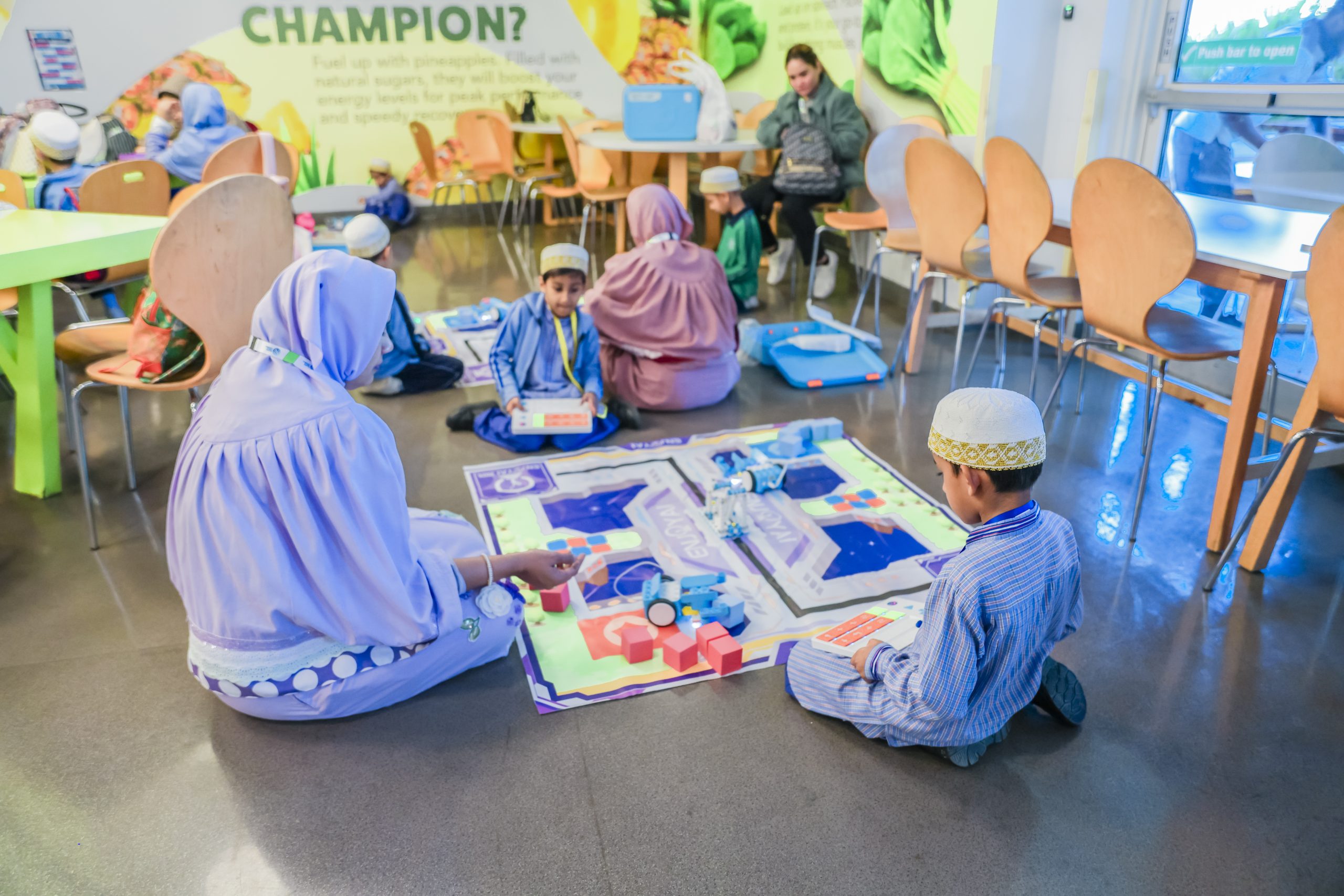 Primary students working on robotics challenge mats during an EduStream STEAM Champions event in the UAE