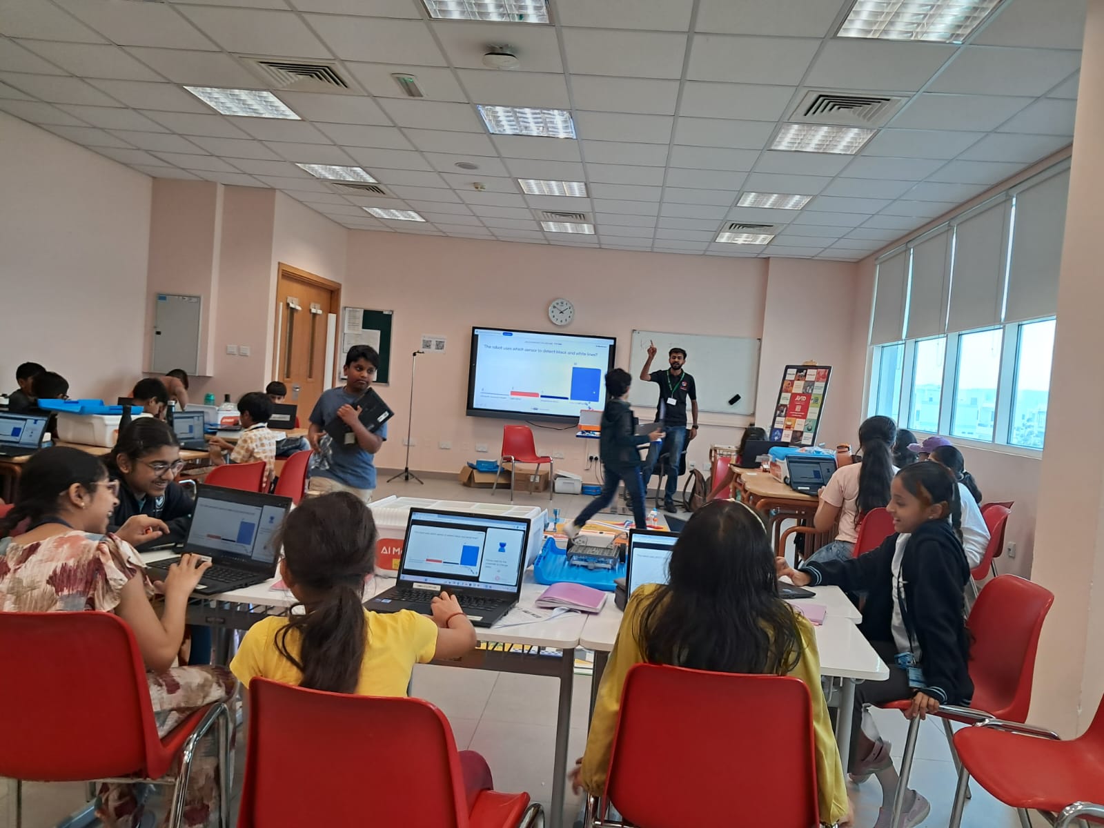Students working at laptops around EduStream activity mats during a STEAM session in a UAE school