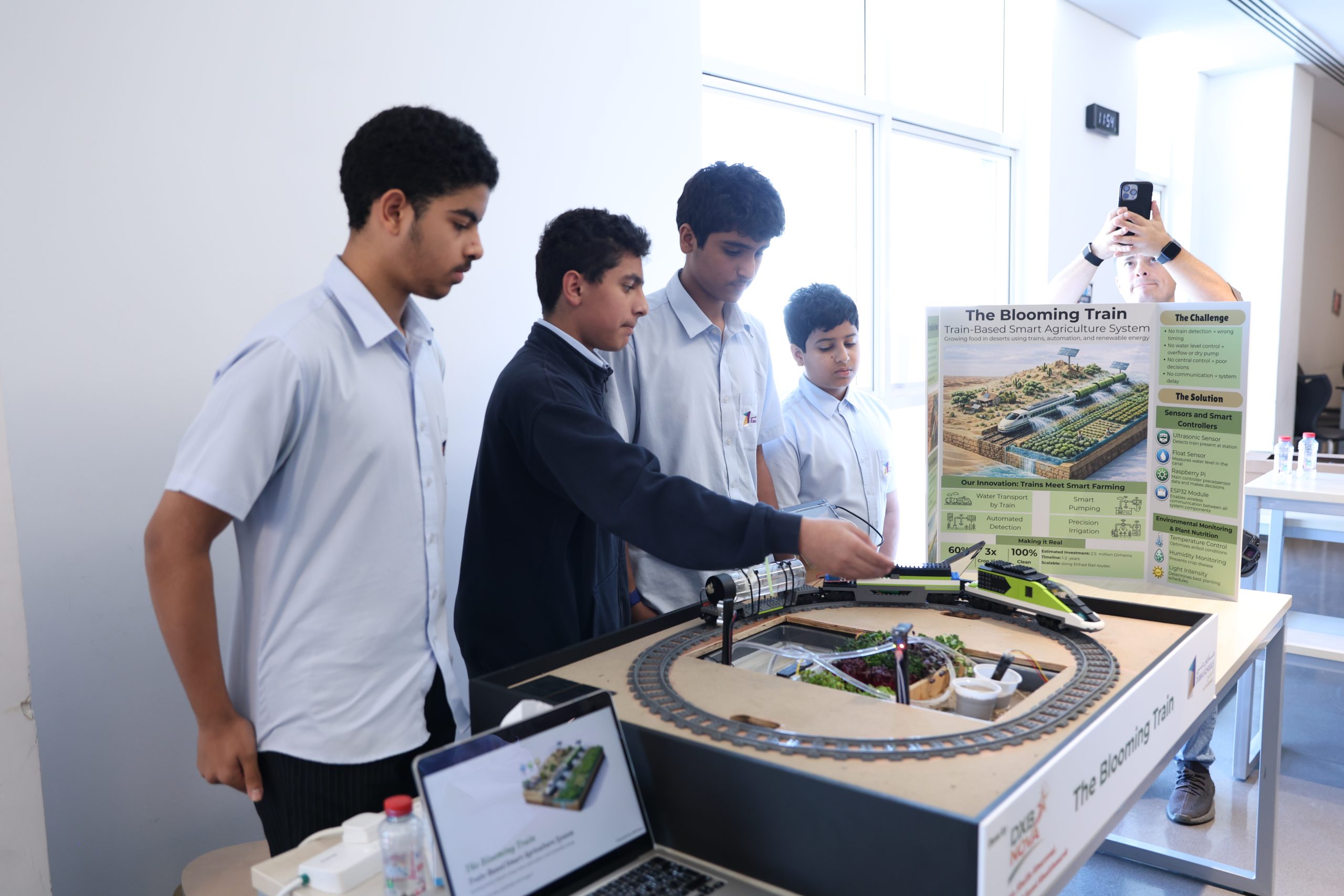 Secondary students demonstrating their AI and robotics project on a working model track in a UAE school innovation space